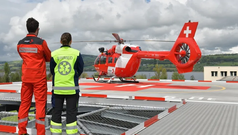 Sirmed und Rega Mitarbeiter vor Rega Helikopter auf dem SPZ