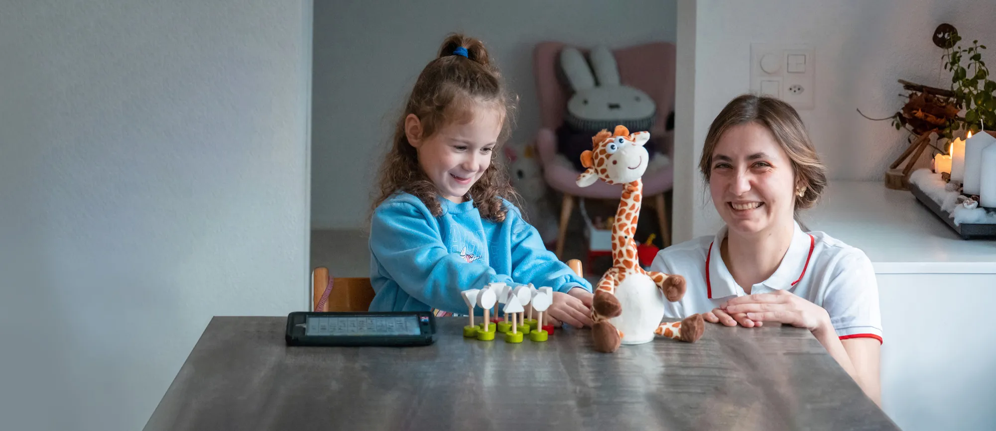 Mia Schuler spielt mit sprechneder Giraffe zusammen mit Beraterin Hannah