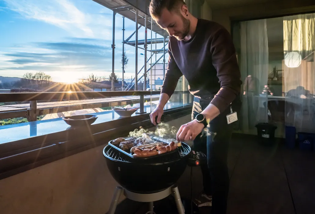 Pascal Moser, Teamleiter der ParaWG, grilliert auf der Dachterrasse für die Bewohnerinnen und Bewohner.