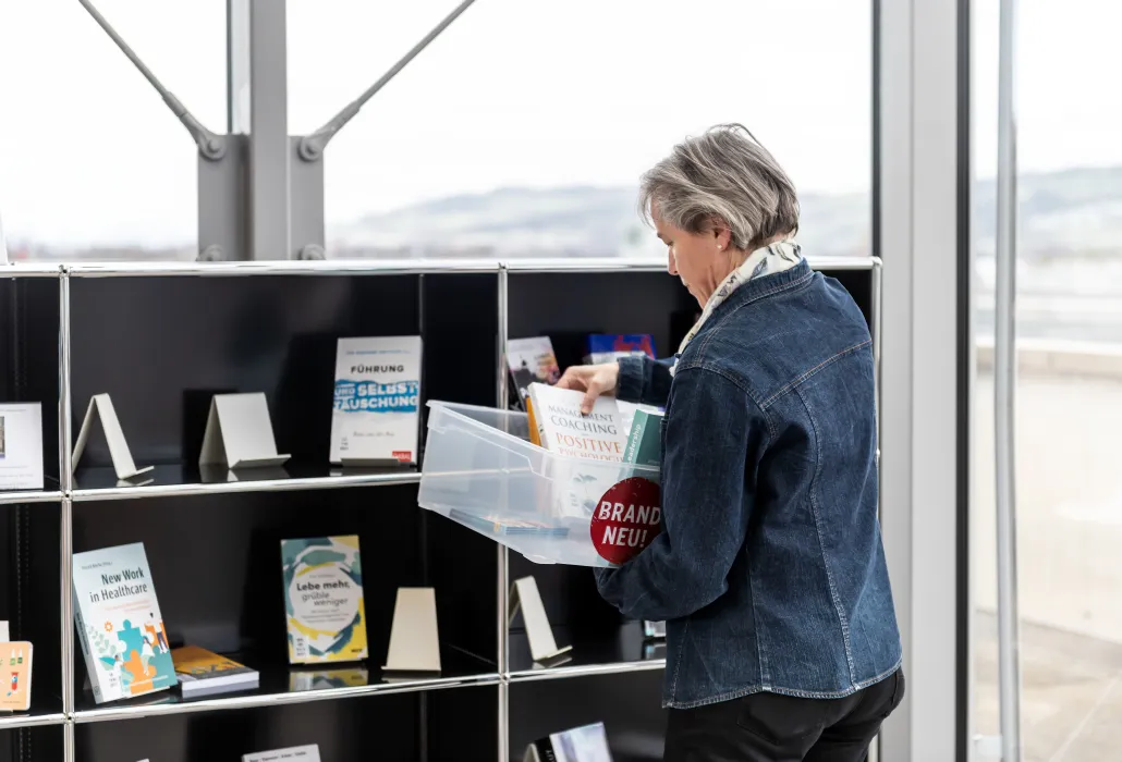 Eine Mitarbeiterin der Bibliothek ordnet Bücher ein.