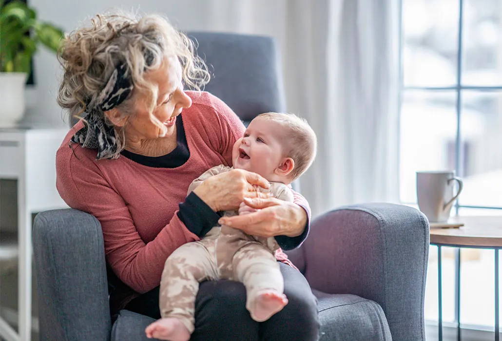 Frau mit lachendem Baby auf dem Arm