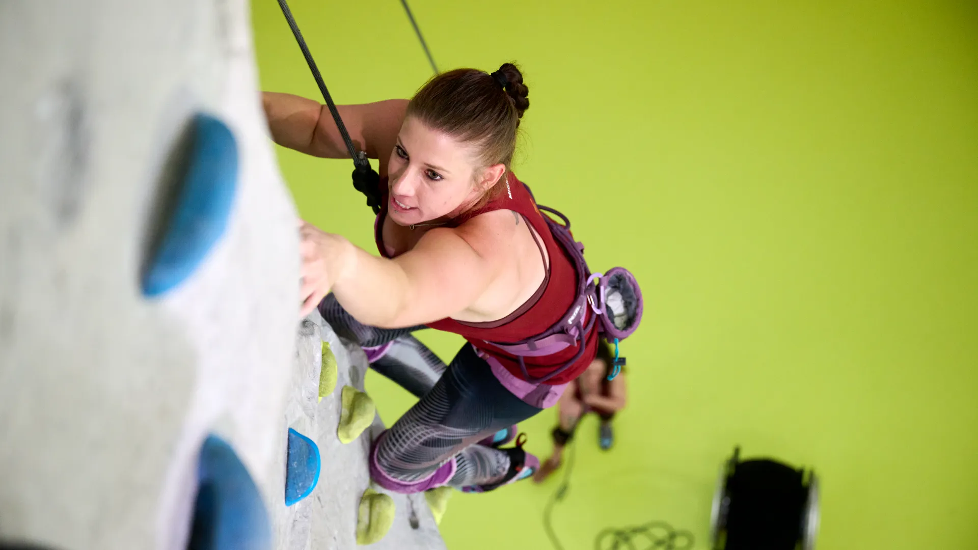 Angela Fallegger an der Kletterwand, gesichert von einer Kollegin am Boden.