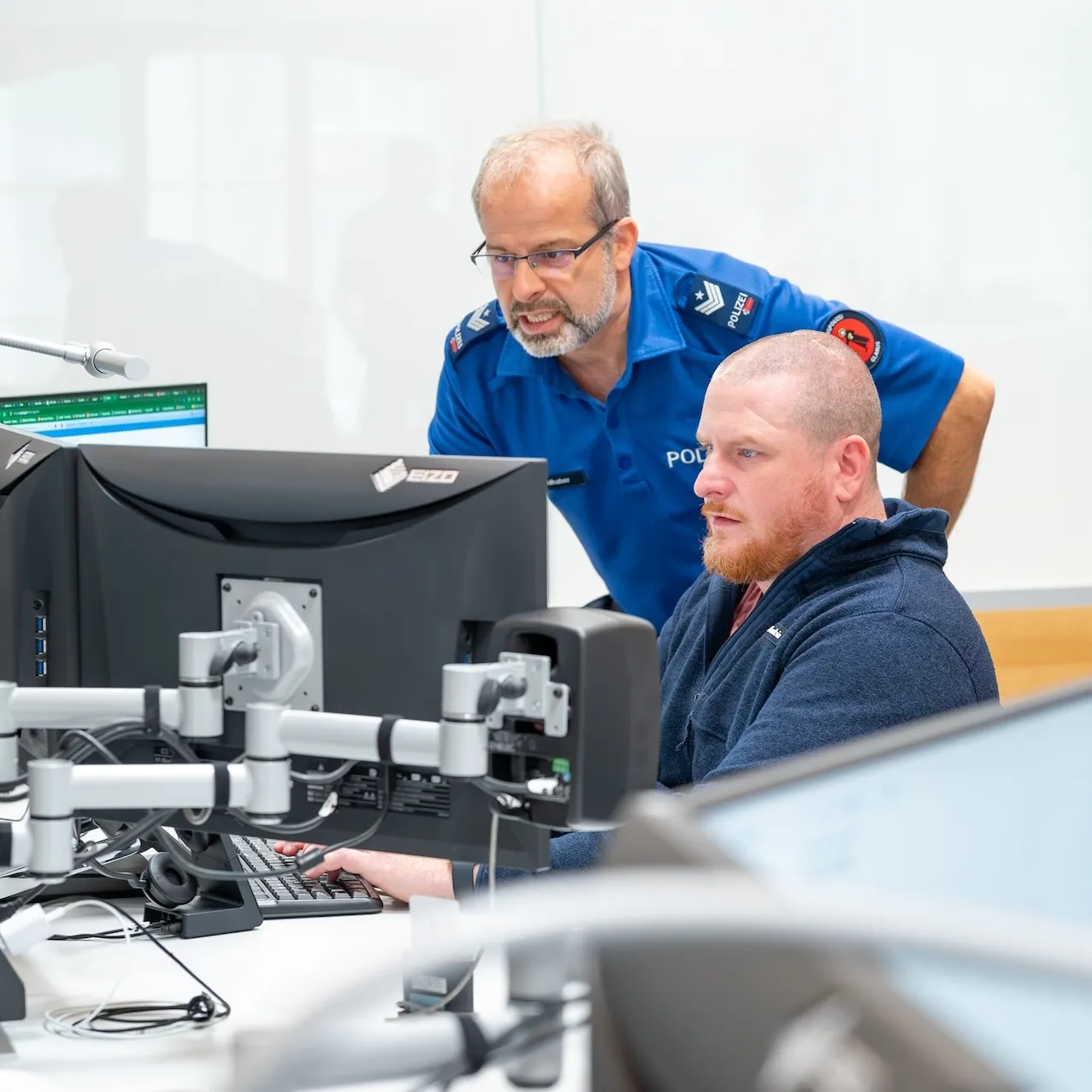 Heiri Dürst in der Einsatzzentrale: Er arbeitet am Computer, während ihm ein Berufskollege über die Schulter schaut.