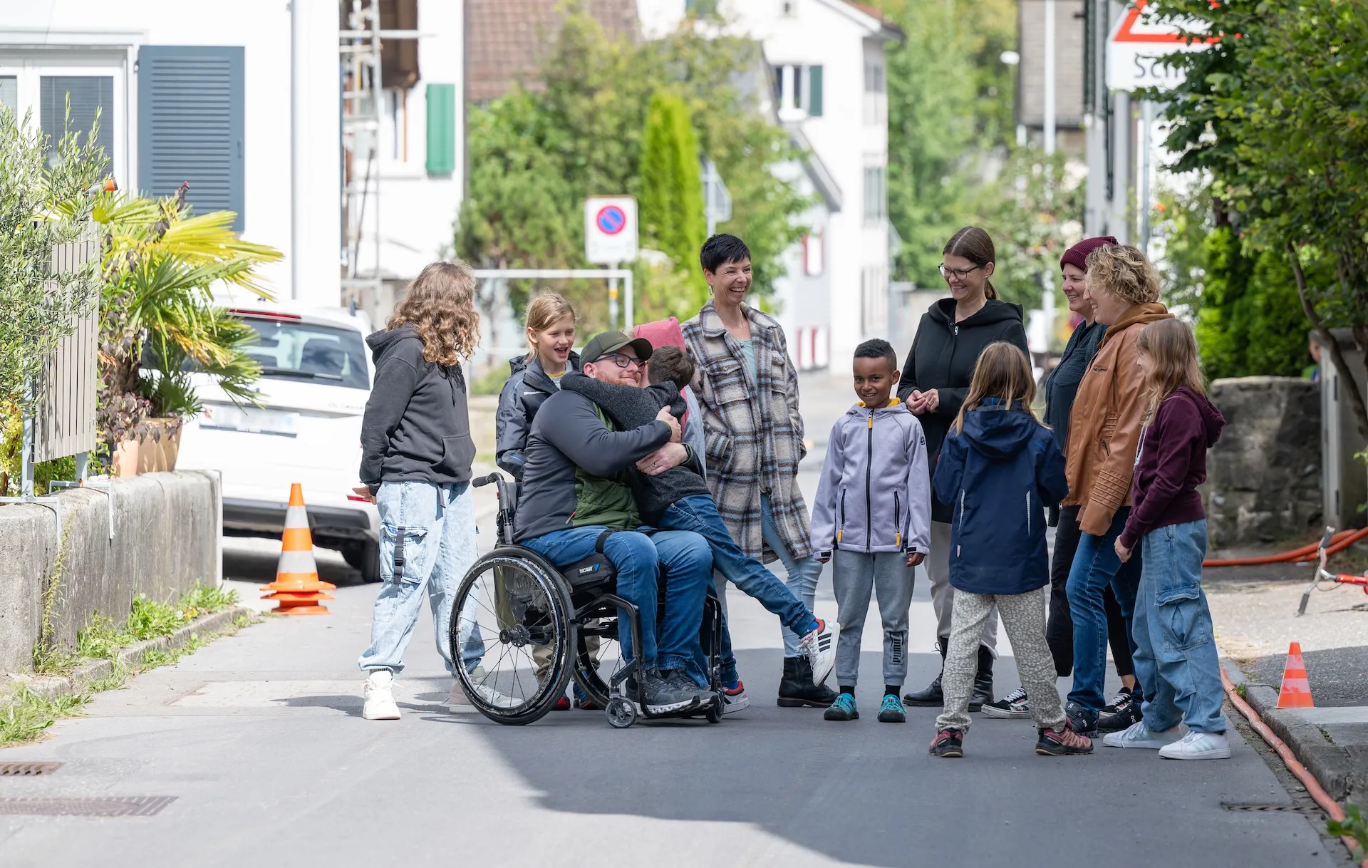 Heiri Dürst mit seiner Familie und Nachbarn auf einer Strasse in seinem Quartier.